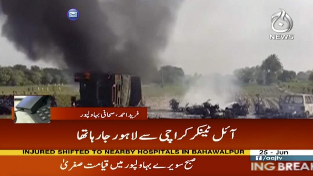In this image taken from video, black smoke rises from oil tanker on road in Bahawalpur, Pakistan, Sunday, June 25, 2017. An overturned oil tanker burst into flames in Pakistan on Sunday, killing people who had rushed to the scene of the highway accident to gather leaking fuel, an official said. (AAJ News via AP Video)