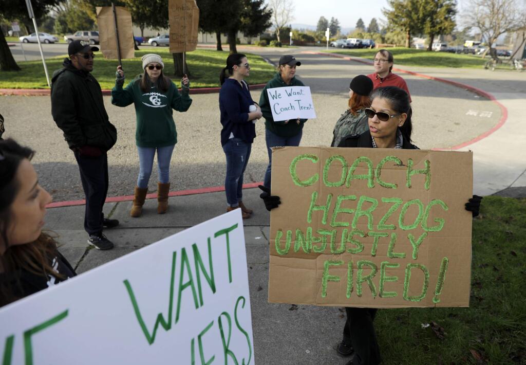 Parents hold up signs demanding answers about the employment status of Casa Grande football coach Trent Herzog outside Casa Grande High School in Petaluma on Tuesday January 31, 2017. (BETH SCHLANKER / The Press Democrat)