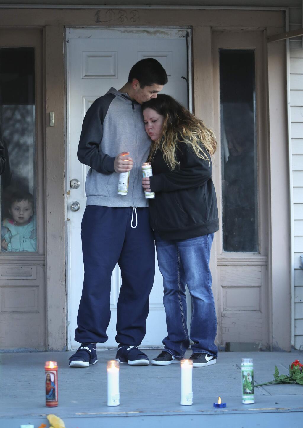 Francis Finch, left, and Tawny Unruh stand quietly on the very spot where Andrew Finch was shot and killed by Wichita Police on Thursday night. Finch was shot by police when a false report of a murder and hostage situation at Finch's address was called into police by an individual performing a prank known as 'swatting.' Francis Finch is Andrew Finch's nephew and Tawny Unruh is the mother of Finch's two children. A candlelight vigil was held at Finch's home of Saturday, Dec. 30, 2017. (Travis Heying/The Wichita Eagle via AP)