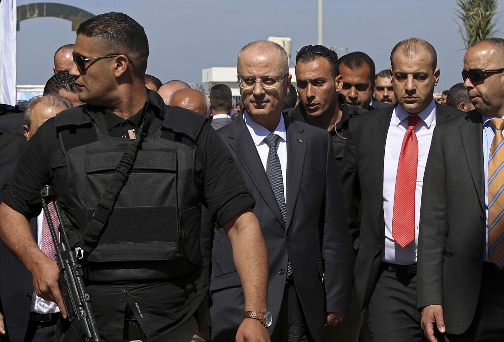 Palestinian Prime Minister Rami Hamdallah, center left, is surrounded by body guards as he arrives for the opening ceremony of a long-awaited sewage plant project, east of Jebaliya, in the northern Gaza strip, Tuesday, March 13, 2018. An explosion occurred as the convoy of the prime minister entered Gaza through the Erez crossing with Israel. The Fatah party of the prime minister called the explosion an assassination attempt and blamed Gaza militants. (AP Photo/Adel Hana)