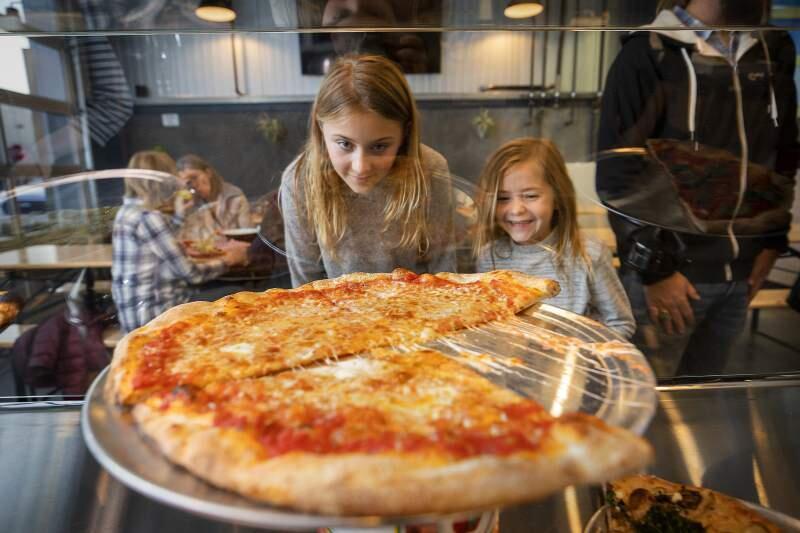 Sailor, left, and Lila Burt of Sebastopol check out the pizza varieties while their parent order at the new Acre Pizza in Sebastopol's Barlow district on Thursday. (photo by John Burgess/The Press Democrat)