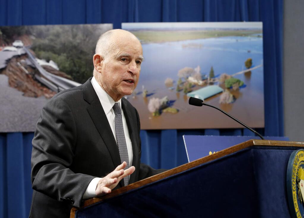 California Gov. Jerry Brown answers a question concerning his proposal to spend $437 million on flood control and emergency response in the wake of recent storms, during a news conference Friday, Feb. 24, 2017, in Sacramento, Calif. In the background are photographs of recent storm damage.(AP Photo/Rich Pedroncelli)