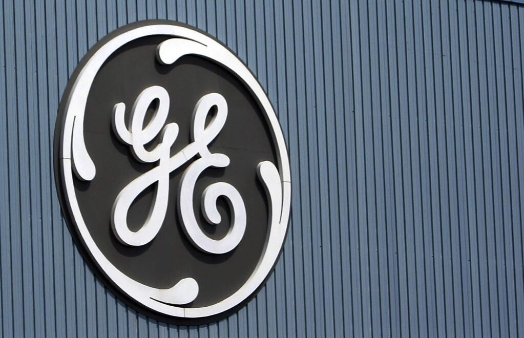 FILE - This June 24, 2014, file photo, shows the General Electric logo at a plant in Belfort, France. On Thursday, Dec. 7, 2017, GE said it will cut 12,000 jobs in its power division as alternative energy supplants demand for coal and other fossil fuels. (AP Photo/Thibault Camus, File)