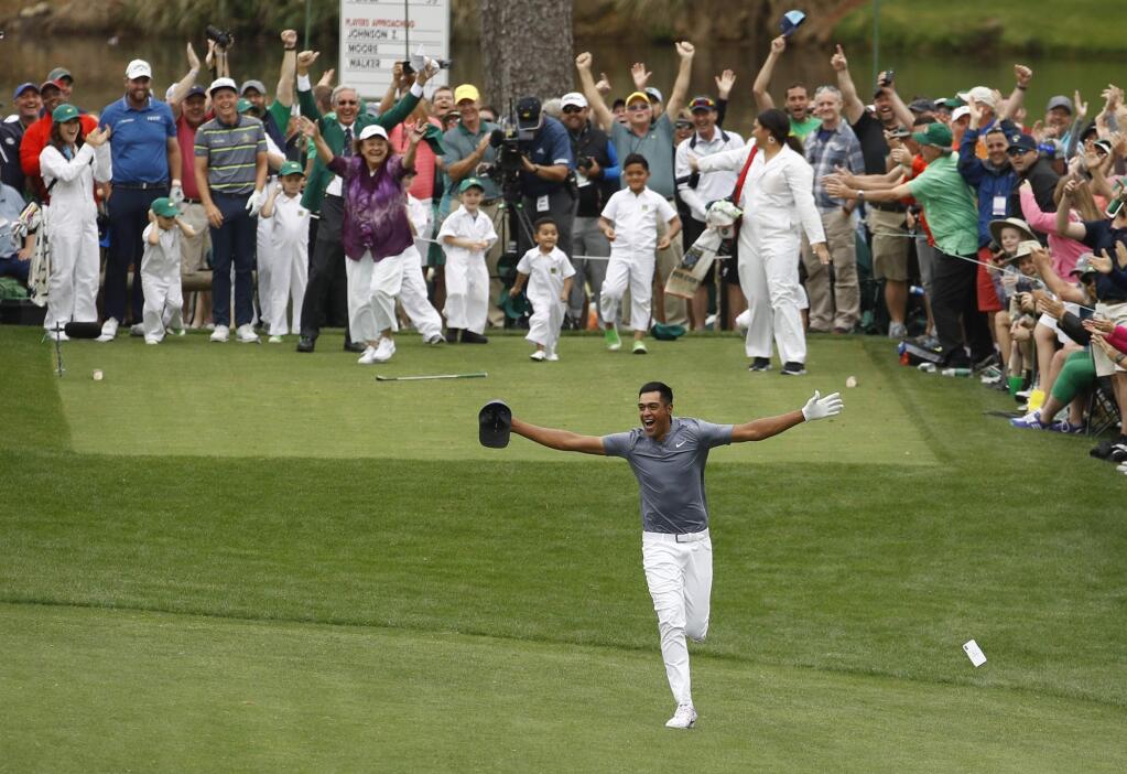 Tony Finau reacts after hitting a hole in one on the seventh home during the par three competition at the Masters golf tournament Wednesday, April 4, 2018, in Augusta, Ga. (AP Photo/Charlie Riedel)