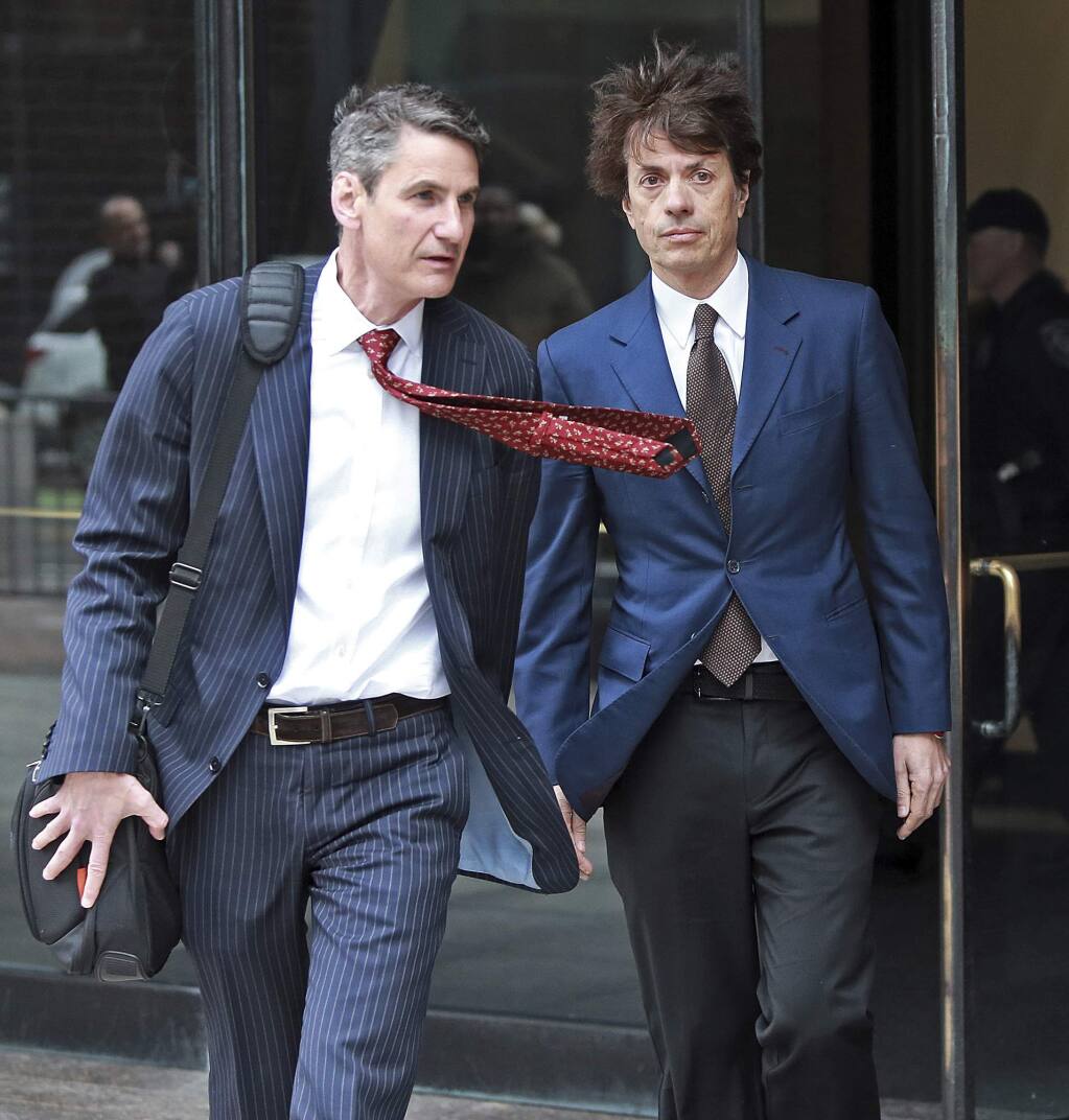 Agustin Huneeus, right, a 53-year-old San Francisco resident whose family owns vineyards in California's Napa Valley and in Oregon, leaves the federal courthouse after a hearing associated with the college admissions bribery scandal, Friday, March 29, 2019 in Boston. Huneeus is accused of paying at least $50,000 to have SAT administrators correct his daughter's college entrance exam and to have USC officials designate her as a water polo recruit. (Matt Stone/The Boston Herald via AP)