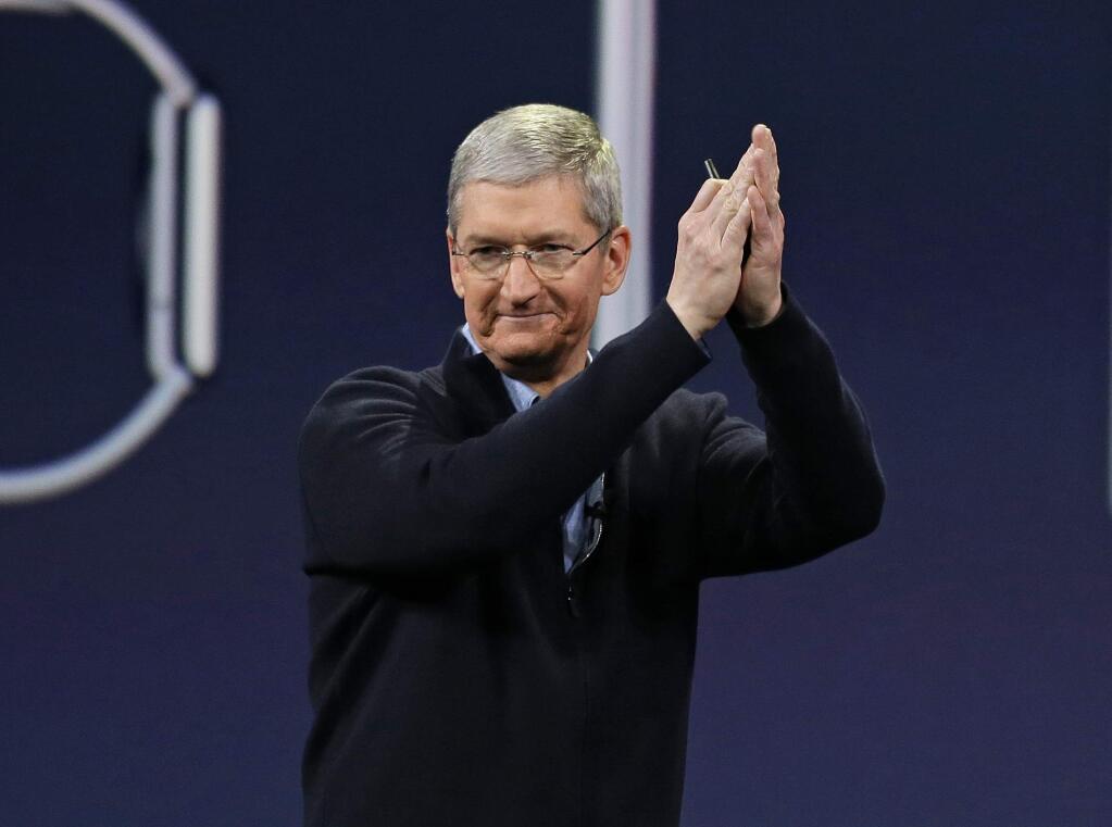 In this Monday, March 9, 2015 photo, Apple CEO Tim Cook applauds at the conclusion of the Apple 'Spring Forward' launch event in San Francisco. Cook took a figurative victory lap at his companys annual shareholder meeting Tuesday, one day after he announced details about the new smartwatch Apple plans to sell next month. (AP Photo/Eric Risberg)