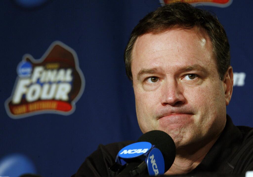 In this Sunday, April 6, 2008 file photo, Kansas head coach Bill Self listens to a question at a news conference before Monday's championship game against Memphis at the NCAA Final Four in San Antonio. The NCAA and networks across the sports dial have infused fans with a hoops fix by rebroadcasting epic NCAA Tournament games. Coaches and players involved in those games are adding insight and a dash of humor by live-tweeting during the replay. (AP Photo/Charlie Neibergall, File)