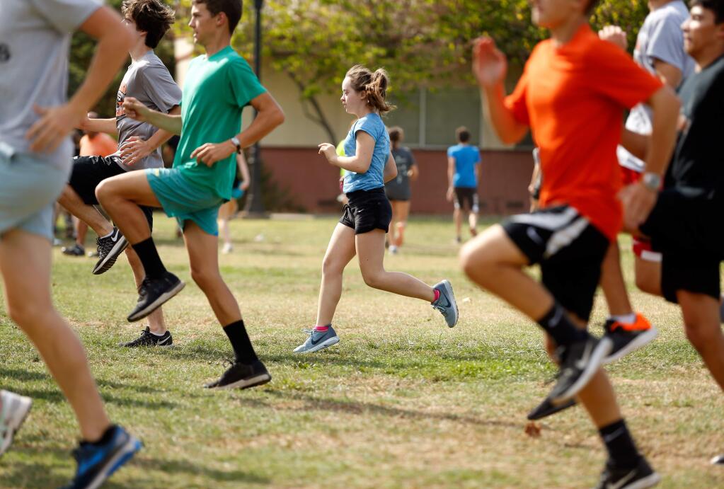 Santa Rosa freshman cross country athlete Hannah Hobaugh, center, performs conditioning drills with her teammates during practice at Santa Rosa High School on Tuesday, Sept. 12, 2017. (Alvin Jornada / The Press Democrat)