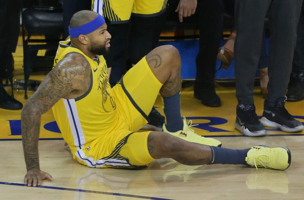Golden State Warriors center DeMarcus Cousins sits on the court after teasring his quadriceps muscle during Game 2 against the Los Angeles Clippers in Oakland on Monday, April 15, 2019. (Christopher Chung / The Press Democrat)
