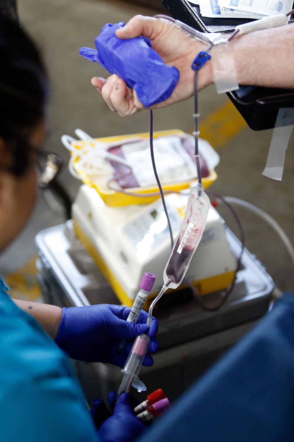Phlebotomist Alejandra Orozco takes a blood donation from Rohnert Park fire marshal Jim Thompson during the 12th annual Bucket Brigade blood drive challenge at Rohnert Park Fire Station 2, in Rohnert Park, California on Saturday, January 6, 2018. (Alvin Jornada / The Press Democrat)