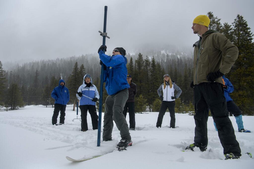 FILE - In this Tuesday, April 2, 2019, file photo, Department of Water Resources Engineer John King, center, thrusts a snow survey tube into the snowpack while conducting the April, 2019 snow survey at the Phillips Station near Echo Summit, Calif. California water officials say the amount of snow blanketing the Sierra Nevada is even bigger than the 2017 snowpack that pulled the state out of a five-year drought. The Department of Water Resources says as of May 30, 2019, the Sierra snowpack measured 202% of average after a barrage of wet storms. (AP Photo/Randall Benton, File)