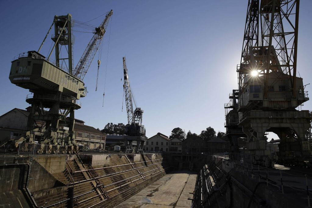 In this photo taken Oct. 2, 2014, the sun begins to go down behind the former Mare Island Naval Shipyard in Vallejo, Calif. The city of Vallejo, which emerged from bankruptcy five years ago, is poised to get a big economic boost as plans to build a major plant for electric cars are rolling forward, officials said Tuesday, May 24, 2016. City leaders later this month will consider and vote on an exclusive negotiating agreement with Faraday Future for a 150-acre plant on the north end of Mare Island, a former U.S. Navy shipyard. (AP Photo/Eric Risberg)
