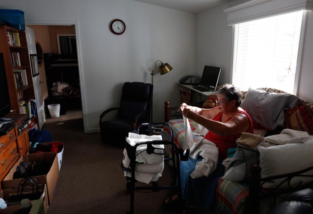 Fran Blaye folds clean towels, her daily house chore, for residents to use at The Haven overnight shelter in Sonoma, California on Wednesday, September 23, 2015. The Haven, operated by Sonoma Overnight Support, is a 10-bed home for low-income adults and families who lack stable housing. (Alvin Jornada / The Press Democrat)
