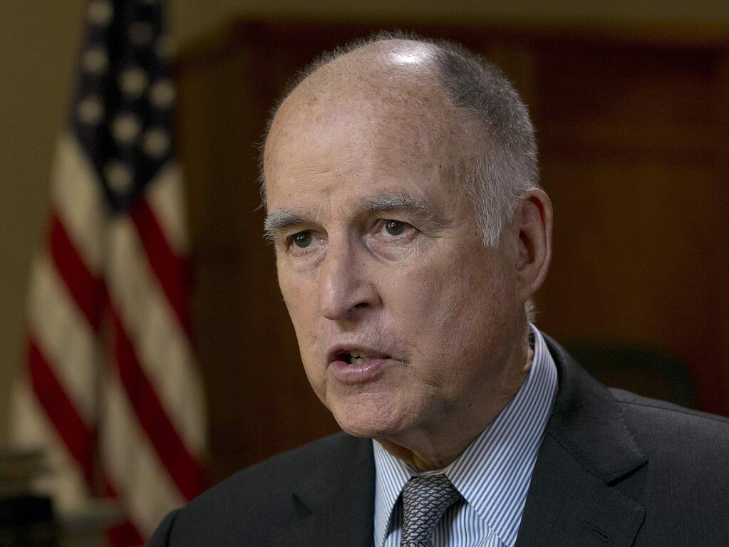 FILE - In this May 31, 2017 file photo, California Gov. Jerry Brown speaks during an interview in Sacramento, Calif. Brown announced yet another plan Wednesday, July 12, 2017, to keep the United States on track to reduce greenhouse gas emissions under the international Paris climate agreement. This time, he's teaming up with former New York City Mayor Michael Bloomberg to launch 'America's Pledge,' an initiative to compile all of the climate change-fighting commitments of states, cities, businesses and universities in one place where they can be easily tracked and shared. (AP Photo/Rich Pedroncelli, File)