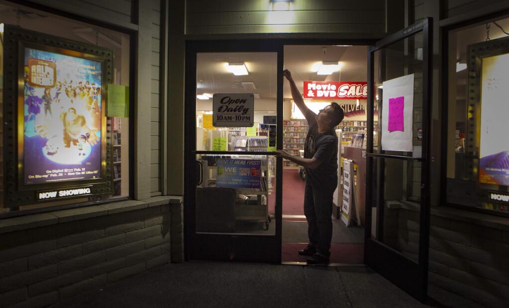 Petaluma, CA, USA._Monday, July 22, 2019._Rigoberto Jaime, the manager of Silver Screen Video closes the doors for the night. The movie rental store will be closing on August 25, 2019, marking the end of an era. (CRISSY PASCUAL/ARGUS-COURIER STAFF)