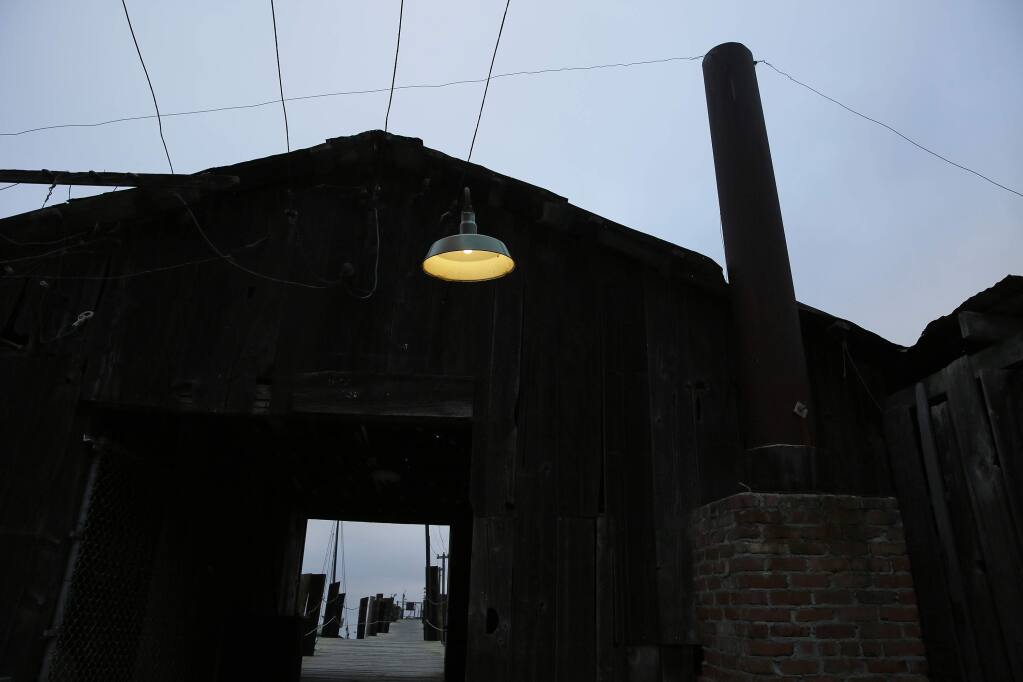 In this photo taken Thursday, Sept. 29, 2016, a light hangs over an entryway to the pier at China Camp State Park in San Rafael, Calif. When the last resident of a ramshackle Chinese shrimping village died, so did a living link to a bit of history little known outside the hikers and bikers who frequent this sparkling spot in Northern California's Marin County. Frank Quan was days from his 91st birthday when he died of natural causes in August at the park. In his long life, he watched as the camp that once numbered hundreds dwindled in size, eventually becoming a state park that had to fight off closure. (AP Photo/Eric Risberg)