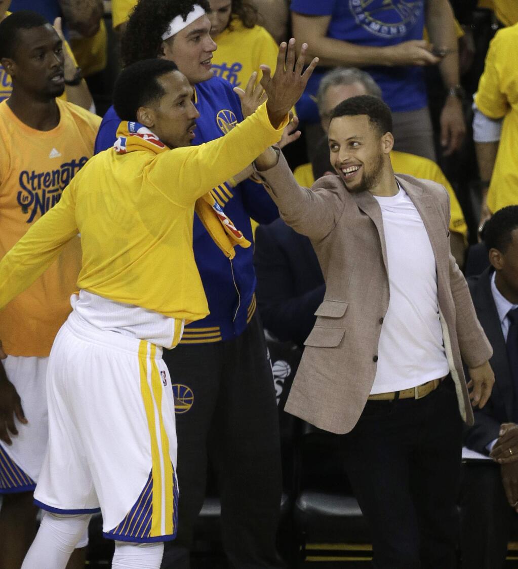 Golden State Warriors' Stephen Curry, right, and Shaun Livingston celebrate a score against the Houston Rockets from the bench during the first half in Game 5 of a first-round NBA basketball playoff series Wednesday, April 27, 2016, in Oakland, Calif. (AP Photo/Ben Margot)