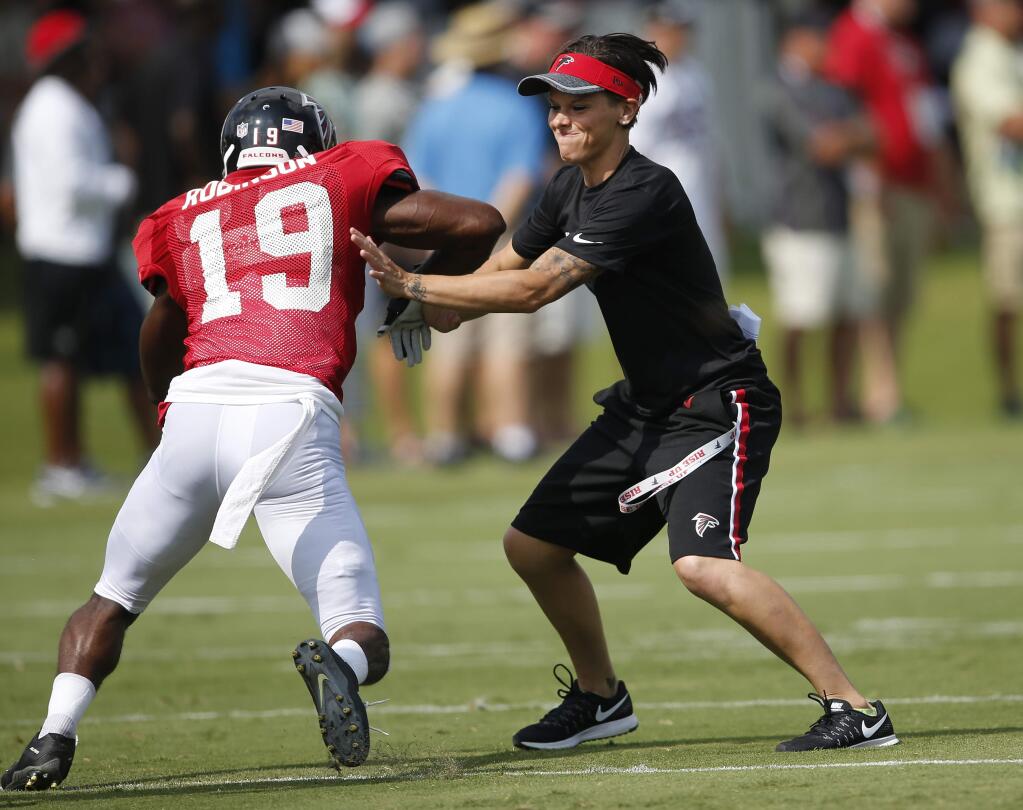 Atlanta Falcons wide receiver Aldrick Robinson works with coaching intern Katherine Sowers during practice Saturday, July 30, 2016, in Flowery Branch, Ga. (AP Photo/John Bazemore)