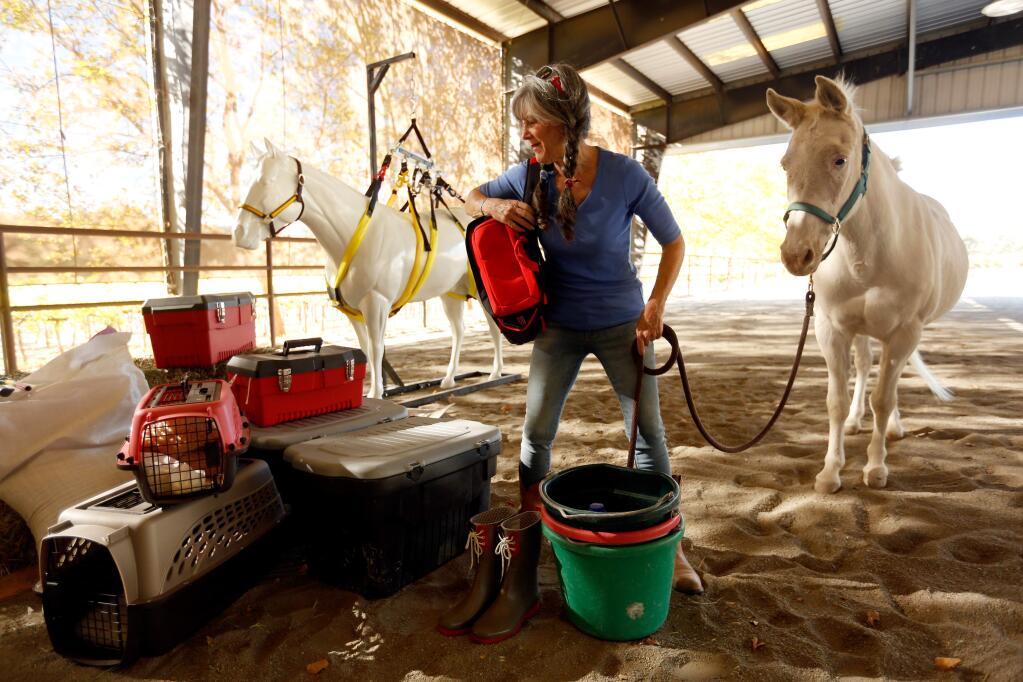 Julie Atwood shows a cache of emergency preparedness supplies she assembled at Atwood Ranch in Glen Ellen, California on Wednesday, October 21, 2015. Atwood's organization, Horses and Livestock Team Emergency Response (HALTER) trains people in rural communities how to manage large animals during disasters. (Alvin Jornada / The Press Democrat)