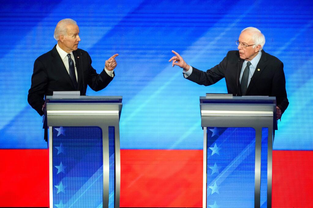 **EMBARGO: No electronic distribution, Web posting or street sales before SUNDAY 3:01 a.m. ET MARCH 15, 2020. No exceptions for any reasons. EMBARGO set by source.**FILE - Sen. Bernie Sanders (I-Vt.), left, and former Vice President Joe Biden argue at the Democratic presidential debate in Manchester, Feb. 7, 2019. The actions of both men in the aftermath of Tuesday's primaries where Biden set out a welcome mat for his rival rather than pressuring him to quit, and Sanders outlined tough terms for an eventual détente, also shed light on a personal relationship that has remained sturdy, amicable and functional, a far cry from the acrimony that defined Sanders's relationship with former Democratic presidential nominee Hillary Clinton after their bitter duel four years ago. (Chang W. Lee/The New York Times)
