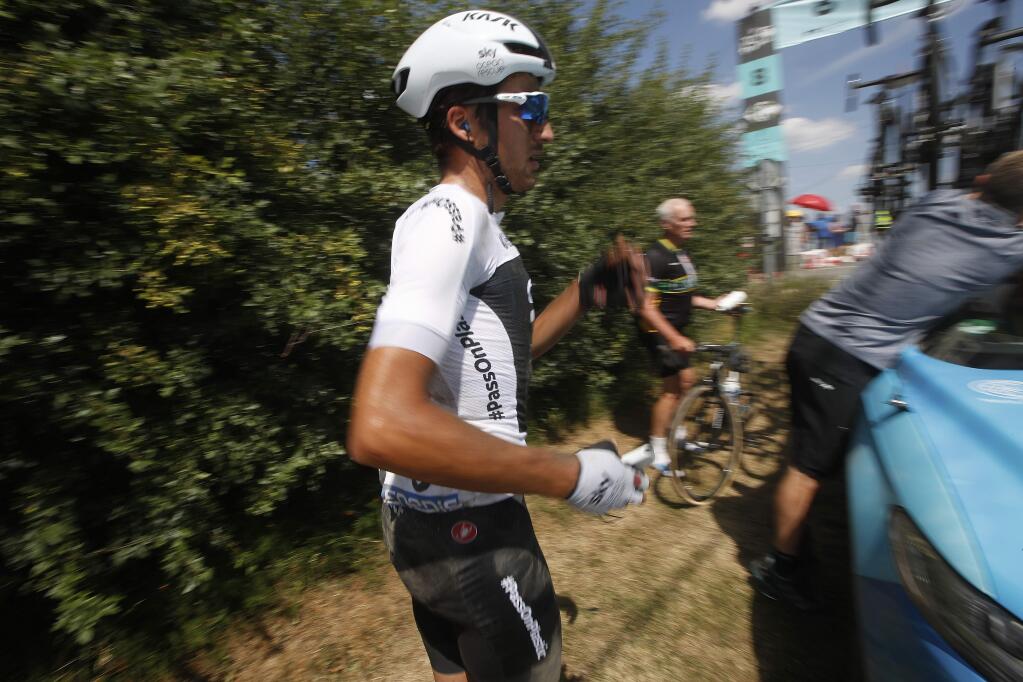 Italy's Gianni Moscon waits for a spare bicycle after crashing on a cobblestone section of the ninth stage of the Tour de France cycling race, Sunday, July 15, 2018. (AP Photo/Christophe Ena)