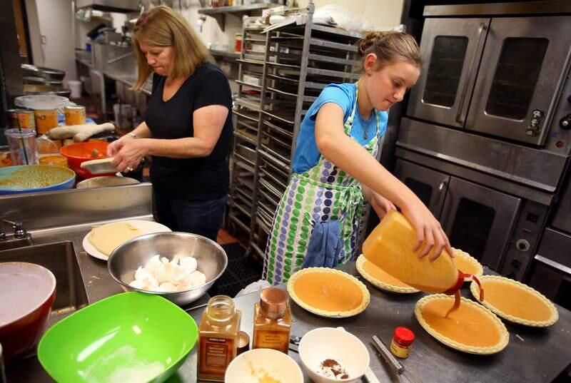 Kati Hilario, right, and her mother, Lisa Ann Hilario, work on baking 75 pumpkin pies at the Fountaingrove Inn's kitchen, in Santa Rosa on Tuesday, November 26, 2013. Kati Hilario, a 14-year-old freshman at Maria Carrillo, is selling the pies to raise money for the Redwood Empire Food Bank.(Christopher Chung/ The Press Democrat)