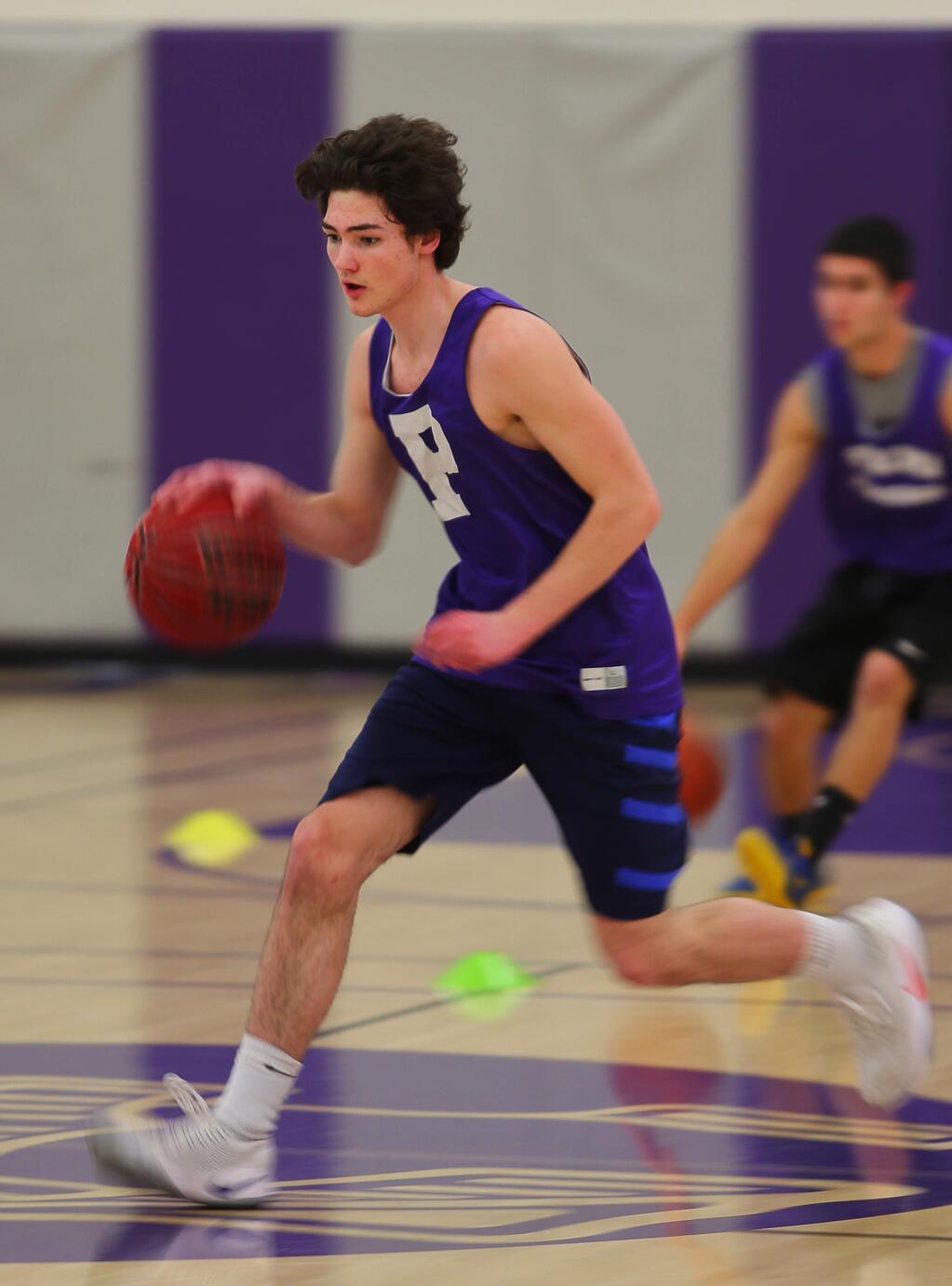 Petaluma's Brendan O'Neill dribbles the ball down the court during warmup drills on Friday, January 13, 2017. (Christopher Chung/ The Press Democrat)
