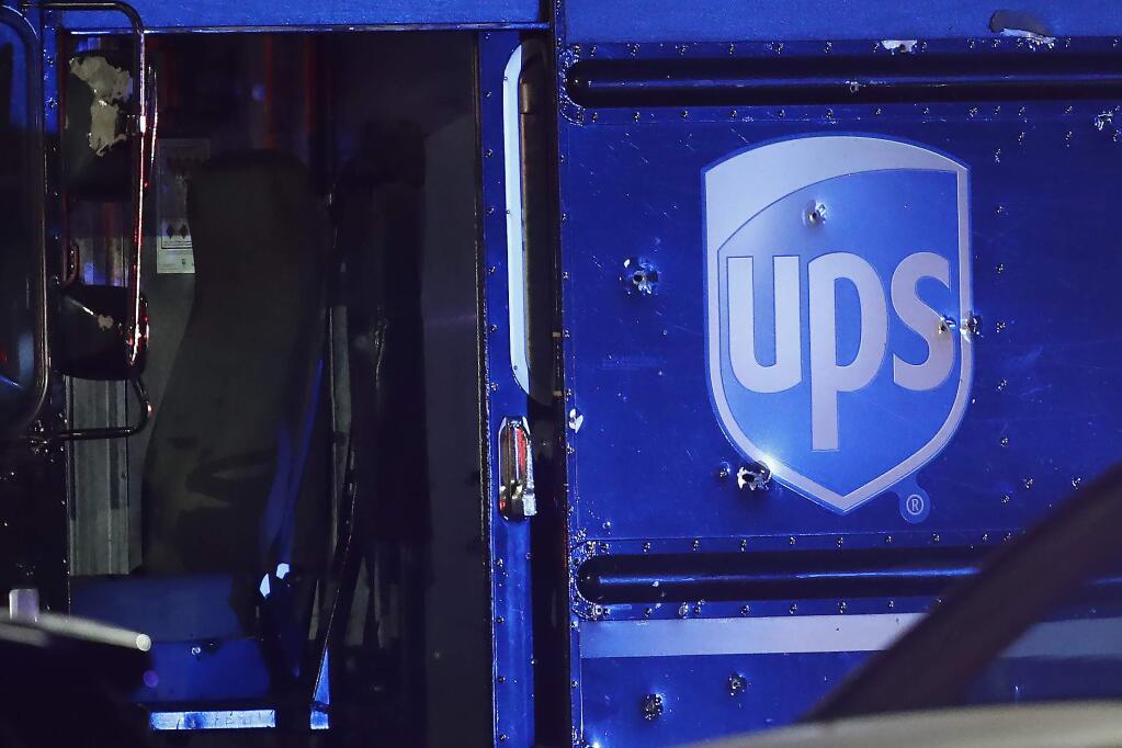 Bullet holes are seen around the UPS logo on a truck at the scene of a shooting Thursday, Dec. 5, 2019, in Miramar, Fla. Four people, including a UPS driver, were killed Thursday after robbers stole the driver's truck and led police on a chase that ended in gunfire at a busy Florida intersection during rush hour, the FBI said. (AP Photo/Brynn Anderson)