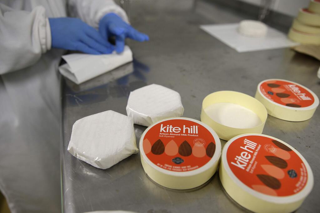 In this Tuesday, June 2, 2015 photo, soft ripened artisan almond milk products are wrapped at the Kite Hill Creamery in Hayward, Calif. Whole Foods Markets sells the vegan product in the dairy cheese case. (AP Photo/Eric Risberg)