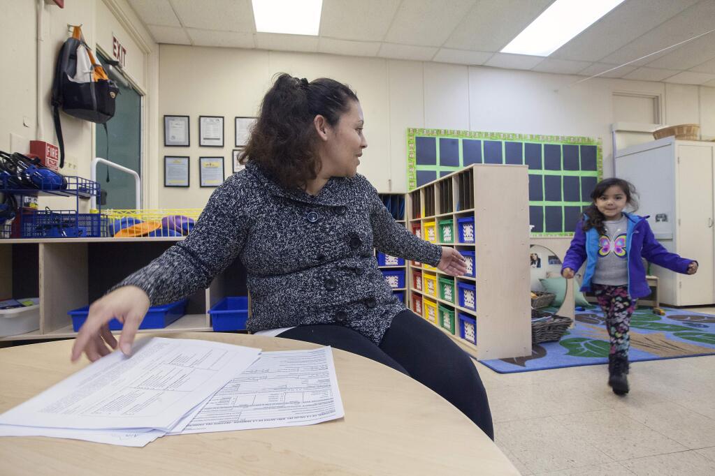 Careli Herrera, 4, who will be starting pre-school in this very classroom at Prestwood Elementary in January, joins her mother Lidia, as she finishes up some paperwork. The pre-school orientation for parents and their children was held on Thursday, Dec 17. (Photo by Robbi Pengelly/Index-Tribune)