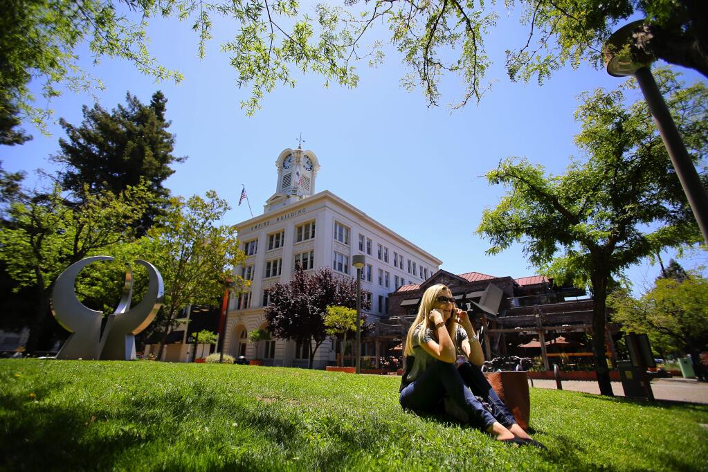 Christa Ranallo relaxes on the grass while talking on the phone in Old Courthouse Square in downtown Santa Rosa in 2015. (CHRISTOPHER CHUNG/ PD FILE)