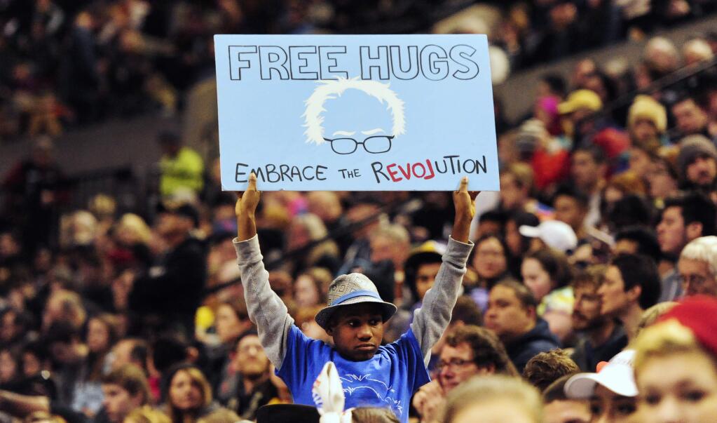 This photo taken March 25, 2016, shows a young supporter holding up a sign as then Democratic presidential candidate Bernie Sanders, I-Vt., addressed the crowd during a rally at the Moda Center in Portland, Ore. Devonte Hart is one of three children who are missing after their siblings and parents were killed when their SUV plunged off a California cliff. Hart had gained fame when a picture of him hugging a white police officer during a protest went viral. (AP Photo/Steve Dykes)