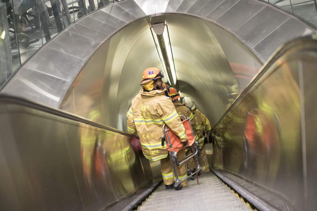New York Fire Dept. EMTs make their way to a track at Penn Station, Friday, April 14, 2017, in New York. A New Jersey Transit train with about 1,200 passengers aboard is stuck in a Hudson River tunnel between New York and New Jersey. Authorities say the Northeast Corridor train became disabled Friday due to an Amtrak overhead power problem. (AP Photo/Mary Altaffer)