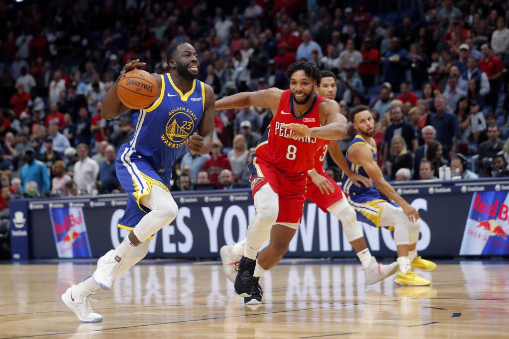 Golden State Warriors forward Draymond Green (23) drives to the basket against New Orleans Pelicans center Jahlil Okafor (8) in the first half of an NBA basketball game in New Orleans, Monday, Oct. 28, 2019. (AP Photo/Gerald Herbert)