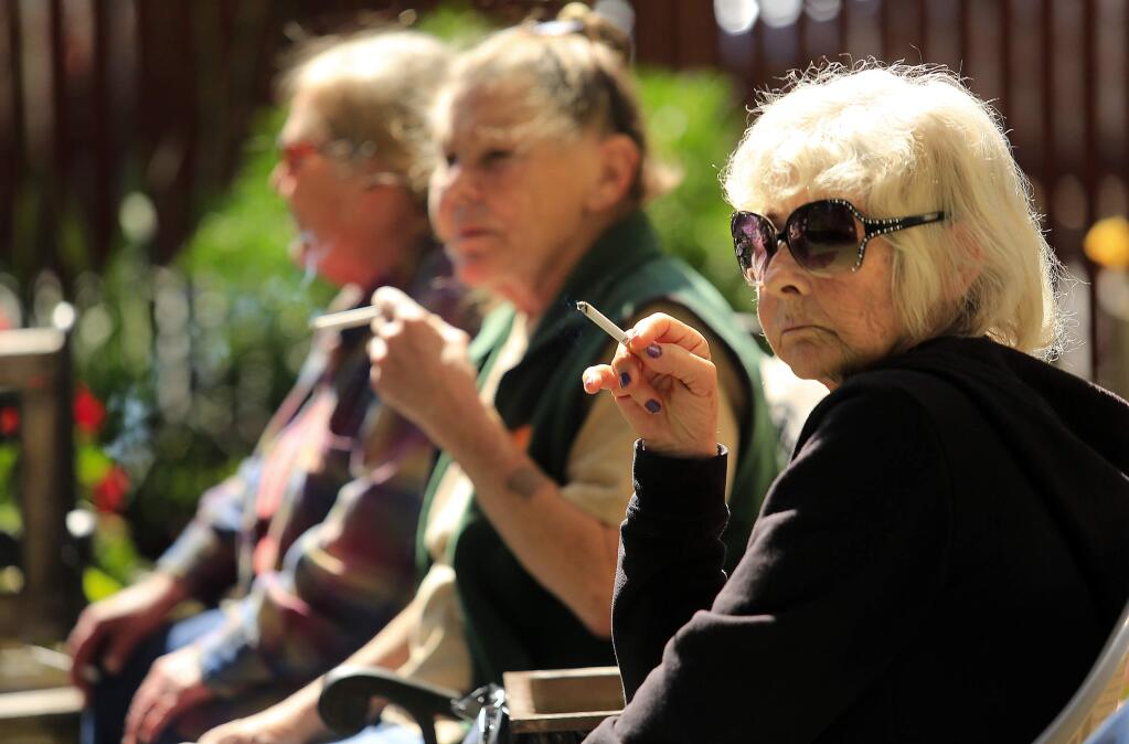 (l to r) Patricia Edwards, Kat Slye and Shirley Ricard smoke in a designated smoking area outside of the Bethlehem Towers in Santa Rosa. (Photo by John Burgess/The Press Democrat)