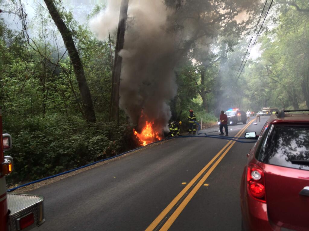 Crews work to extinguish a blaze after a crash on Eastside Road on Monday, July 6, 2015. (COURTESY OF CHRISTOPHER O'GORMAN)