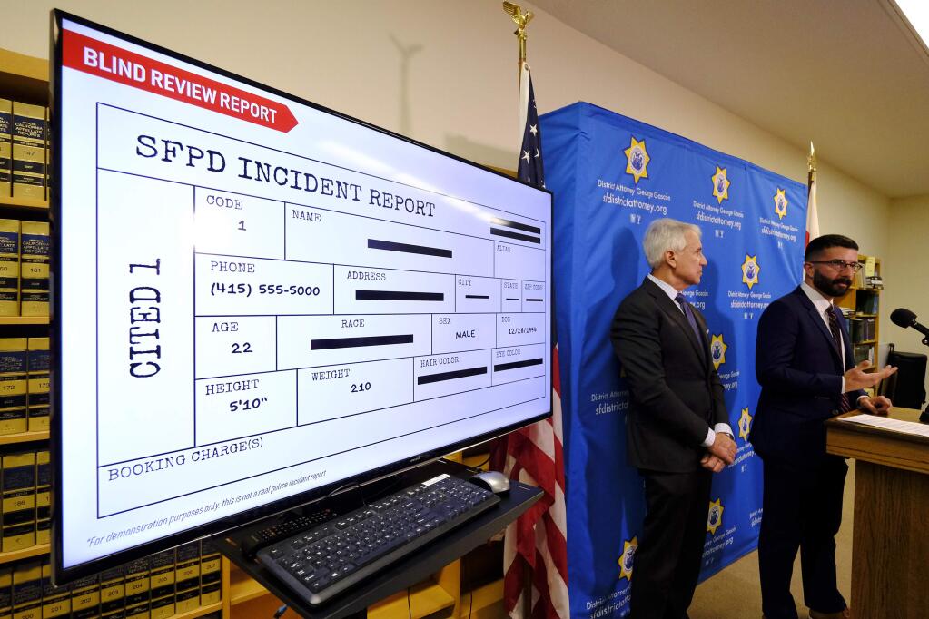 With a blind police incident report displayed, San Francisco District Attorney George Gascon, left, and Alex Chohlas-Wood, Deputy Director, Stanford Computational Policy Lab, talk about the implementation of an artificial intelligence tool to remove potential for bias in charging decisions, during a news conference Wednesday, June 12, 2019, in San Francisco. In a first-of-its kind experiment, San Francisco prosecutors are turning to artificial intelligence to reduce bias in the criminal courts. (AP Photo/Eric Risberg)