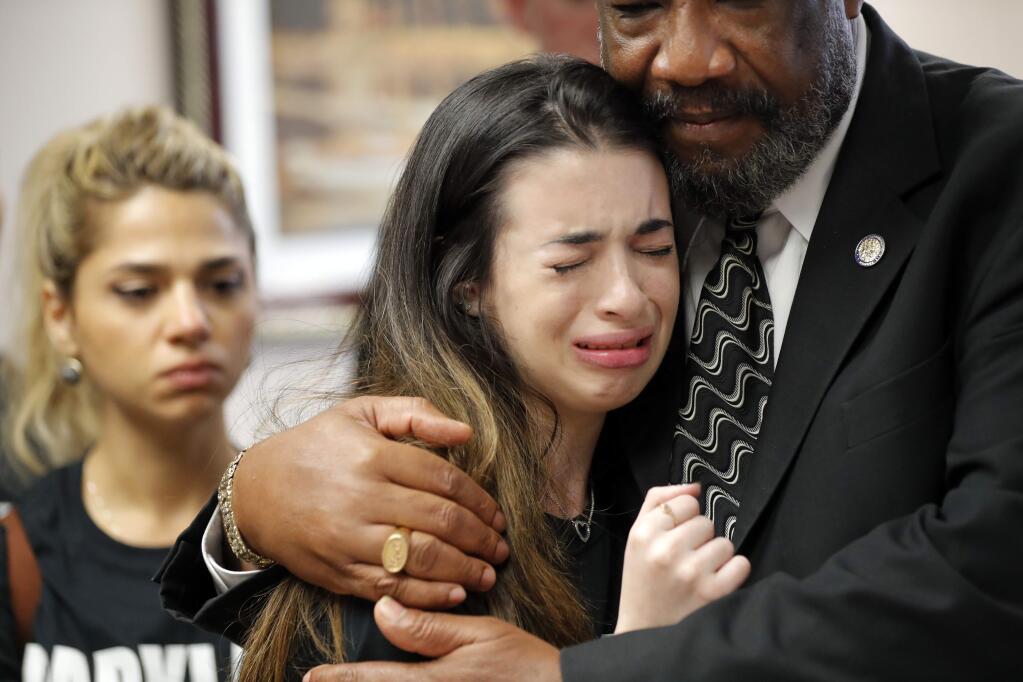 Aria Siccone, 14, a 9th grade student survivor from Marjory Stoneman Douglas High School, where more than a dozen students and faculty were killed in a mass shooting on Wednesday, cries as she recounts her story from that day, while state Rep. Barrinton Russell, D-Dist. 95, comforts her, as they talk to legislators at the state Capitol regarding gun control legislation, in Tallahassee, Fla., Wednesday, Feb. 21, 2018. (AP Photo/Gerald Herbert)
