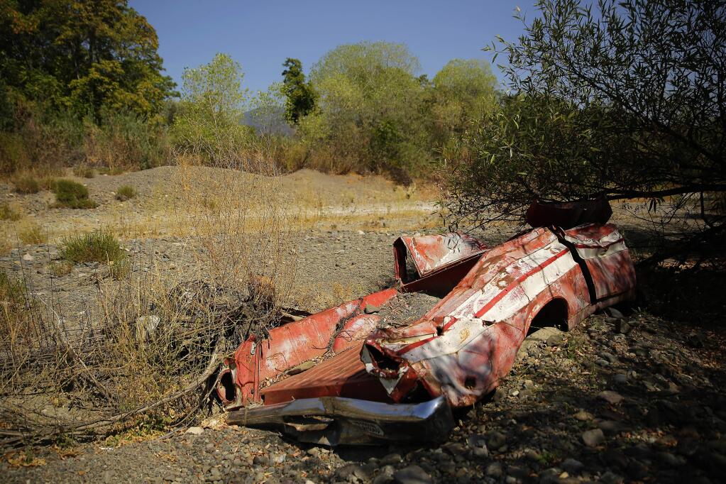 An old truck embedded in the Kelsey Creek bed lays completely dried near downtown Kelseyville on Saturday, August 9, 2014. (Conner Jay/The Press Democrat)