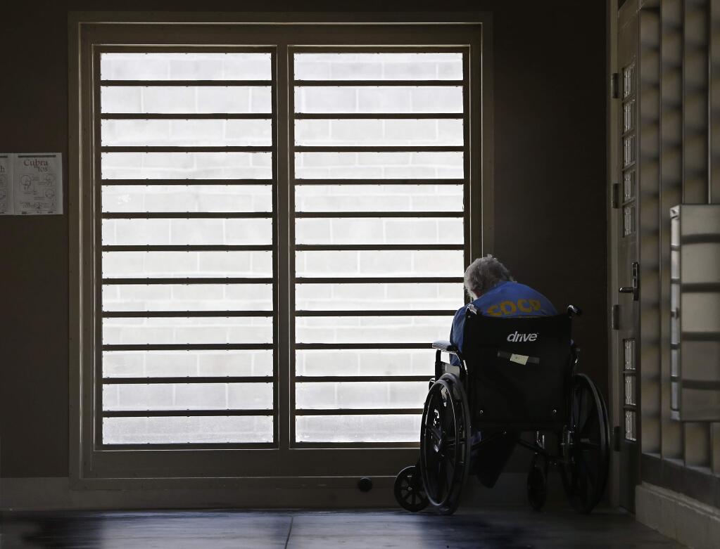 In this Thursday, July 24, 2014 photo, an inmate sits by a window at the mental health unit at the California Department of Corrections and Rehabilitation's Stockton Health Facility in Stockton. The California Association of Psychiatric Technicians union says that employees at the facility were instructed to routinely falsify suicide watch records, endangering inmates and violating standards imposed in response to federal court orders. (AP Photo/Rich Pedroncelli)