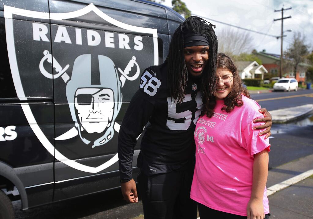 Oakland Raiders linebacker Neiron Ball gives Petaluma High School senior Michelle Larsen a hug before leaving, after presenting her with a $5,000 check from the Bay Area All-Star Scholarship Team in Petaluma, on Friday, March 11, 2016. (Christopher Chung / The Press Democrat)