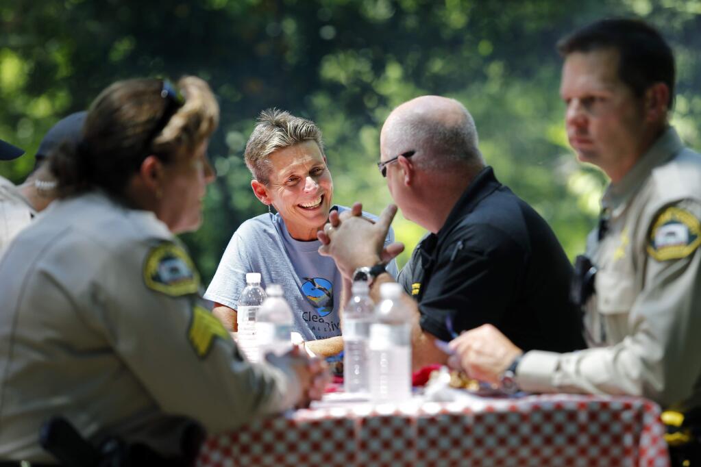 Robin Johnson, center, a volunteer with Clean River Alliance, talks to Sonoma County Sheriff Steve Freitas during a barbecue, hosted by the Guerneville Community Alliance, to thank local law enforcement and first responders at Guerneville River Park in Guerneville, on Monday, June 27, 2016. (BETH SCHLANKER/ The Press Democrat)