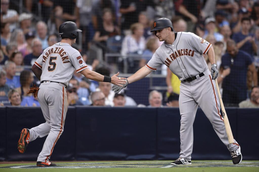 San Francisco Giants' Mike Yastrzemski is congratulated by Alex Dickerson after scoring on a single by Pablo Sandoval during the sixth inning of a baseball game against the San Diego Padres, Saturday, July 27, 2019, in San Diego. (AP Photo/Orlando Ramirez)