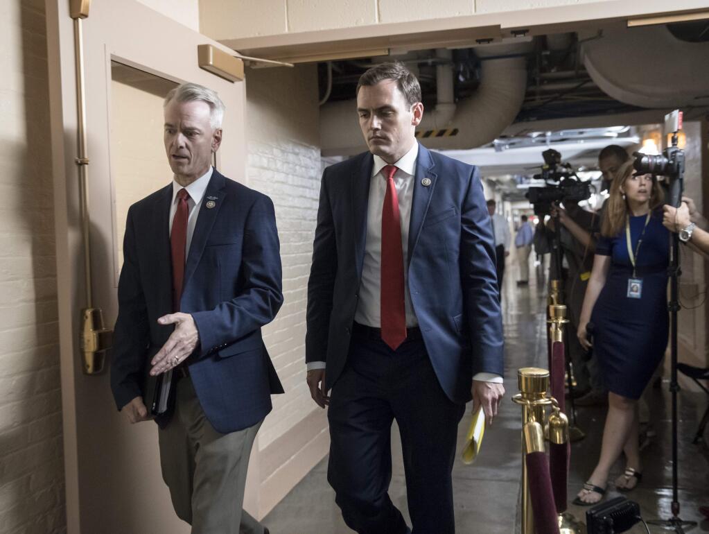 Rep. Steve Russell, R-Okla., left, and Rep. Mike Gallagher, R-Wis., walk to a closed-door meeting with House Republicans seeking more information about compromise legislation on immigration, at the Capitol in Washington, Thursday, June 21, 2018. (AP Photo/J. Scott Applewhite)