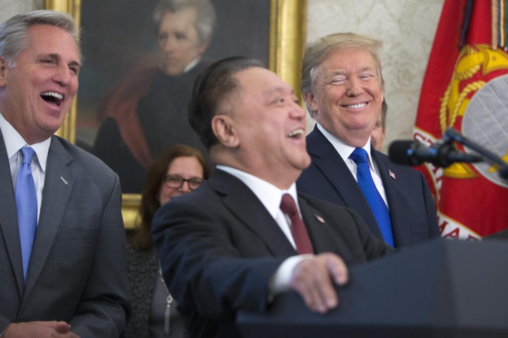 Hock Tan, center, chief executive of Singapore-based Broadcom, with President Donald Trump during a news conference, on Capitol Hill in Washington, Nov. 2, 2017. Broadcom unveiled on Nov. 6, a $105 billion takeover bid for Qualcomm, the biggest such effort ever in the technology industry and a prelude to a potential merger battle between two of the world's biggest chip makers. At left is House Majority Leader Kevin McCarthy. (Tom Brenner/The New York Times)
