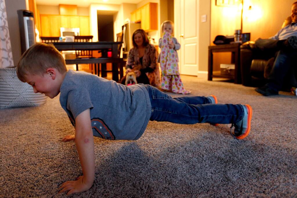 Cody Nix, 6, practices his pushups while his family unwinds at the end of the day in their new home in Santa Rosa, California, on Wednesday, March 21, 2018. The Nix Family experienced an insurance shortfall when they tried to rebuild their home in the Larkfield neighborhood burned down in the Tubbs fire. (Alvin Jornada / The Press Democrat)