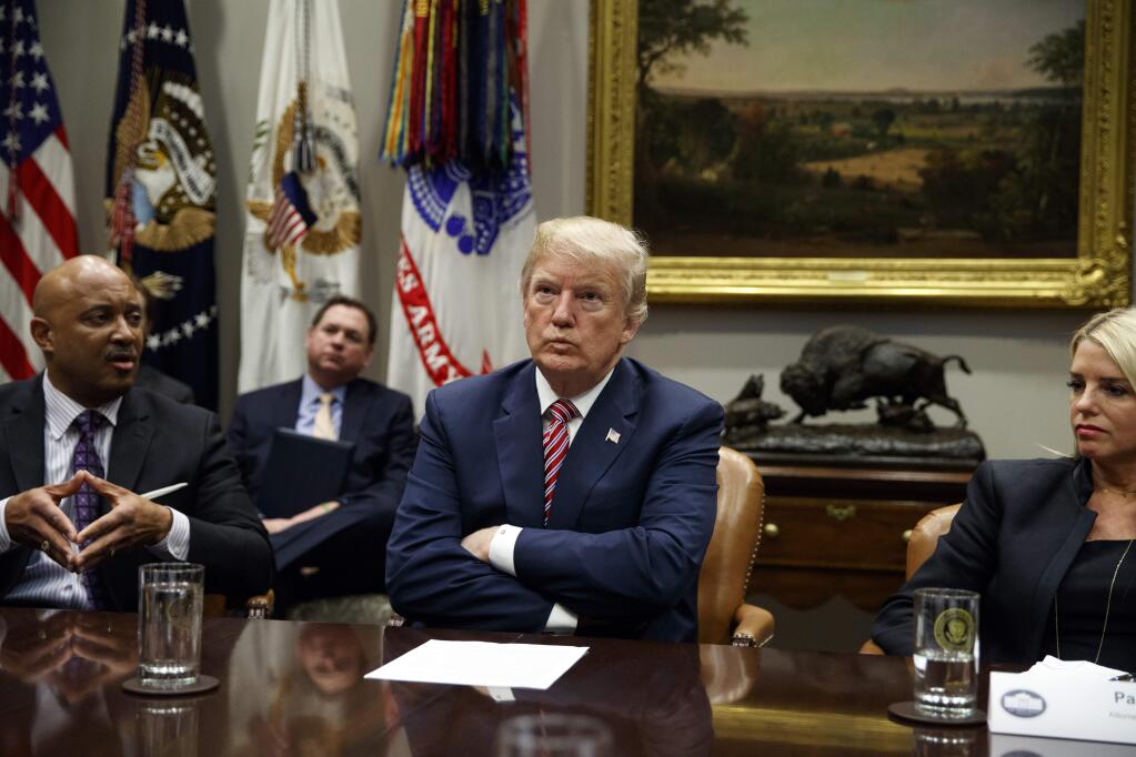Florida Attorney General Pam Bondi, right, and President Donald Trump listen as Indiana Attorney General Curtis Hill speaks during a meeting with state and local officials to discuss school safety, in the Roosevelt Room of the White House, Thursday, Feb. 22, 2018, in Washington. (AP Photo/Evan Vucci)