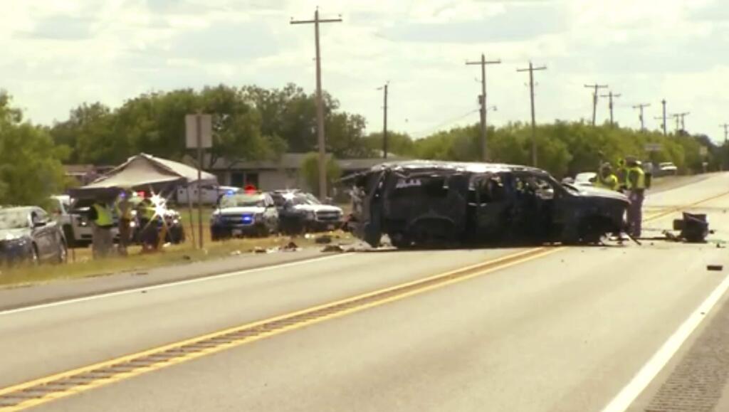 This frame grab from video provided by KABB/WOAI in San Antonio shows the scene on Texas Highway 85, where authorities say multiple people are dead and others hurt as an SUV carrying more than a dozen people crashed, Sunday, June 17, 2018, in Big Wells, Texas, while fleeing from Border Patrol agents. (Courtesy of KABB/WOAI via AP)