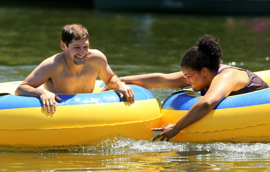 Maya Webster cheats and holds back Dale Waters in the inner tube race at the Big Rocky Games on the Monte Rio beach. (John Burgess / The Press Democrat)