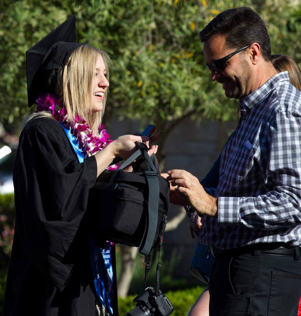Alexis Simmons, graduating in Business Marketing, laughs with her father, Layne Simmons, of Fortuna, Calif., as they prepare for the 2017 Commencement for the School of Business and Economics at Sonoma State University, in Rohnert Park, Calif., on Saturday, May 20, 2017. (Photo by Darryl Bush / For The Press Democrat)